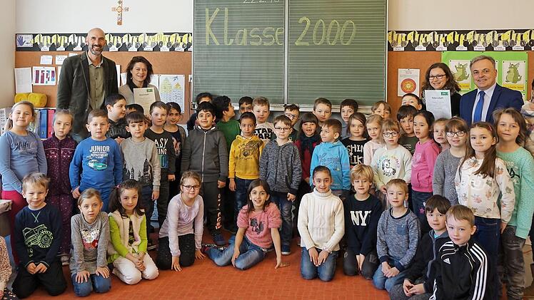 Die Klassen 1a und 1c der Sinnberg-Schule nehmen am Schulpräventionsprojekt Klasse 2000 teil. Lothar Zachmann (hintere Reihe, 2. v. rechts) von der AOK überreichte die Urkunde an Rektor Karl-Heinz Deublein (hinten, links) und die Klassenlehrerinnen Petra Arnold (hinten, 2. v. links) und Julia Lenhart (hinten, 3. von rechts). Foto: Denise Zehe