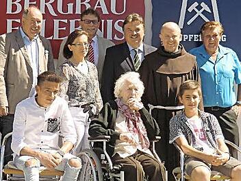 Jubilarin Marie Hahn (M.) im Kreise der Familie und Gratulanten (v.l.): Zweiter Bürgermeister Alfred Kolenda, Urenkel Alex, Enkelin Ilona Pöhlmann, Peter Sandler, Landrat Klaus Peter Söllner, Pater Alard, Urenkel Ulli und Kirchenpfleger Waldemar Hebda.  Foto: kpw