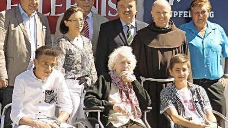 Jubilarin Marie Hahn (M.) im Kreise der Familie und Gratulanten (v.l.): Zweiter Bürgermeister Alfred Kolenda, Urenkel Alex, Enkelin Ilona Pöhlmann, Peter Sandler, Landrat Klaus Peter Söllner, Pater Alard, Urenkel Ulli und Kirchenpfleger Waldemar Hebda.  Foto: kpw