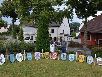 Maler Peter Kautzner (l.) mit dem stellvertretenden Bürgermeister Hans Wichert und die neu restaurierten Zunftzeichen für den Kerwabaum.