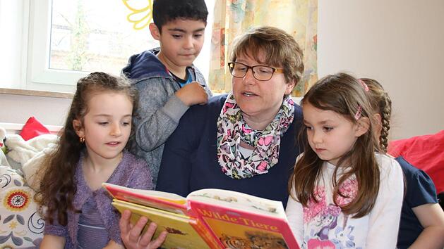 Kinder lieben es, wenn Erwachsene vorlesen. Hier liest die Leiterin des Kliegl-Kindergartens Manuela Sauer Geschichten von Wilden Tieren vor. Gespannt lauschen Dascha (von links), Hasan, Lisa und Sophie. Foto: Kathrin Kupka-Hahn