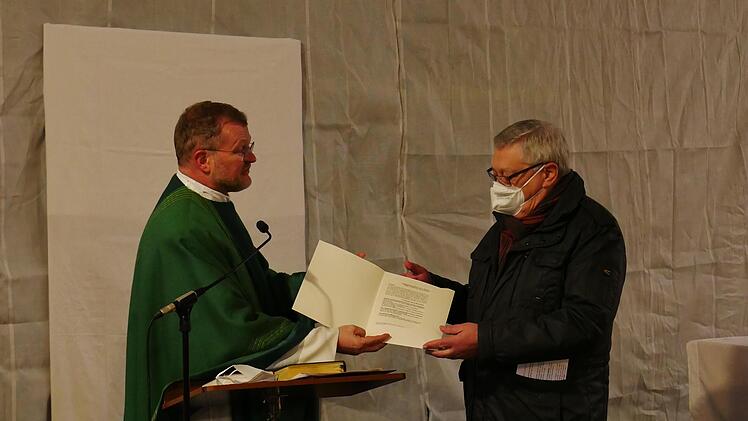 Erhard Ledermann  nimmt als Vertreter der Laien die Errichtungsurkunde für den Pastoralen Raum Münnerstadt aus den Händen von Generalvikar Jürgen Vorndran entgegen. Foto: Heike Beudert
