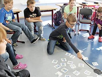 In diesem Klassenzimmer werden nicht Fliegen, sondern Zahlen mit der Fliegenklatsche "erlegt". Wer die Lösung der Rechenaufgabe weiß, klatscht auf die richtige Zahl (Bild links). Ebenfalls sehr beliebt: Verknoten. Ein Mitschüler soll dieses Knäuel vorsichtig wieder entwirren. Der Sinn dahinter? Wir gehören zusammen! Foto:Katja Müller
