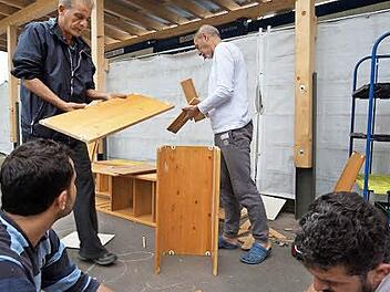 Flüchtlinge bauen aus alten Regalen Blumenkästen. Hinten sind Emad Mansour und Amjad Alaa Deen zu sehen. Foto: Arkadius Guzy