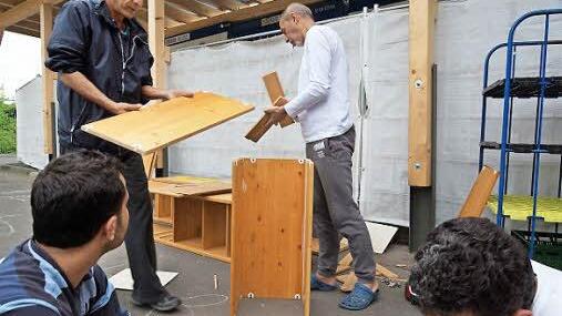 Flüchtlinge bauen aus alten Regalen Blumenkästen. Hinten sind Emad Mansour und Amjad Alaa Deen zu sehen. Foto: Arkadius Guzy