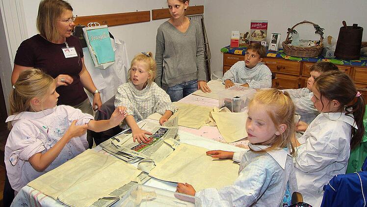 Schloss Aschach besuchten die Kinder des Ferienprogramms des Generationenetzes und der Arbeiterwohlfahrt. In der Schlossmühle durften sie unter Anleitung von Museumspädagogin Susanne Bocklet (links im Hintergrund) Stofftaschen herstellen.  Foto: Dieter Britz
