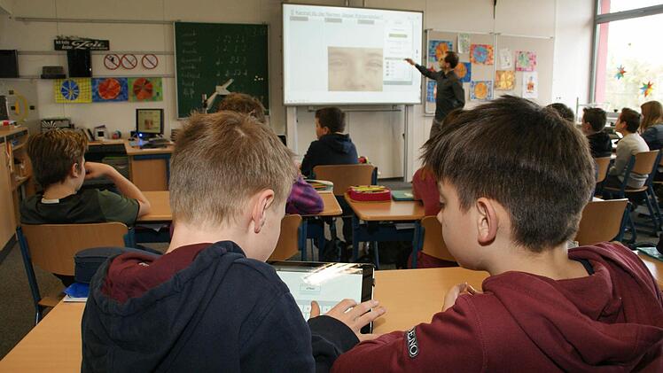 Dennis und Hannes haben gerade ihre Lösung auf das interaktive Whiteboard zu ihrem Klassenlehrer Tim Lamm geschickt. Für die beiden ist klar: sie möchten nächstes Jahr wieder in das bisher einzige Klassenzimmer mit digitaler Tafel.  Foto: Sabine Weinbeer