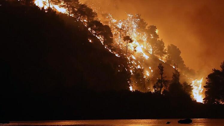 Ein Feuer w&uuml;tet in den W&auml;ldern der griechischen Insel Eub&ouml;a und f&auml;rbt den Nachthimmel im Jahr 2021 orange - es sollte sich um den bis dahin gr&ouml;&szlig;ten Waldbrand in der j&uuml;ngeren griechischen Geschichte handeln.