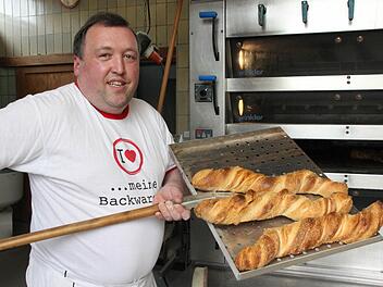 Hubert Ruß holt das Wurzelbrot aus dem Ofen. Fotos: Corinna Igler