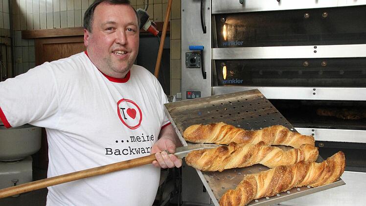 Hubert Ruß holt das Wurzelbrot aus dem Ofen. Fotos: Corinna Igler