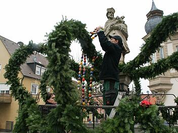 Die bunten Eierschnüre um die Osterbrunnenbögen zu winden, ist Teamarbeit. Bianca Kowalewicz, Daniela Antogiovanni und Gerlinde Hornung bei der Arbeit. Foto: Sabine Weinbeer