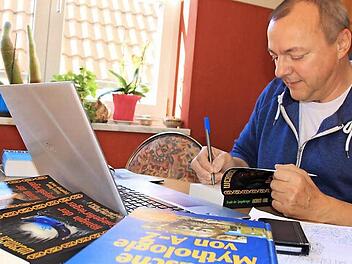 Werner Karl in seinem Wohnzimmer, wo er am Laptop seine Fantasy-Romane verfasst. Foto: Matthias Einwag