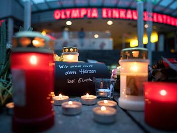 Blumen und Kerzen liegen vor dem Olympia-Einkaufszentrums in München. Die tödlichen Schüsse hat ein 18-jähriger Deutsch-Iraner abgegeben. Zehn Menschen starben, darunter der Täter. Foto: Sven Hoppe/dpa