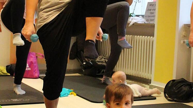 Während Mama Lena Schmidt die Übungen macht, spielt ihr Sohn Leo vor ihr auf der Matte. Foto: Lisa Kieslinger