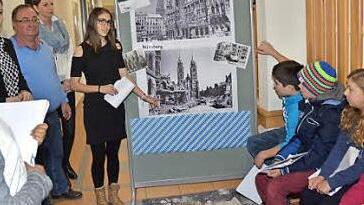 Aleyna Karatas an der Schautafel und Carina Jungkunz (2. v. l.) erklärten die Anfänge, wie es zur bayerischen Verfassung kam, und zeigten Bilder von zerbombten Städten. Foto: Karl-Heinz Hofmann