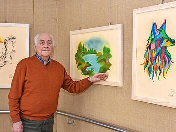 Horst Kreutz steht vor einigen der Kunstwerke, die von Marzieh Haydari gemalt wurden und im Seniorenzentrum St. Elisabeth in der Kleinen Galerie gezeigt werden.  Foto: Björn Hein