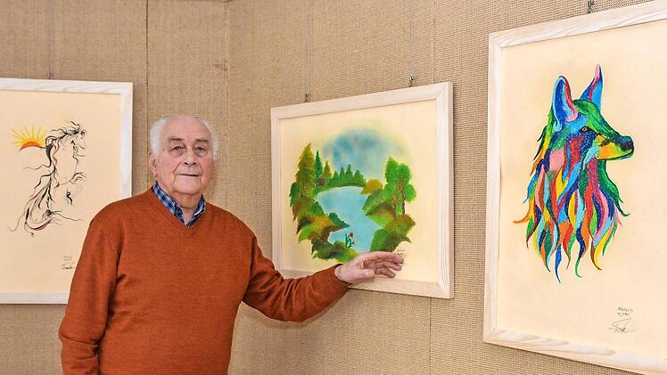 Horst Kreutz steht vor einigen der Kunstwerke, die von Marzieh Haydari gemalt wurden und im Seniorenzentrum St. Elisabeth in der Kleinen Galerie gezeigt werden.  Foto: Björn Hein