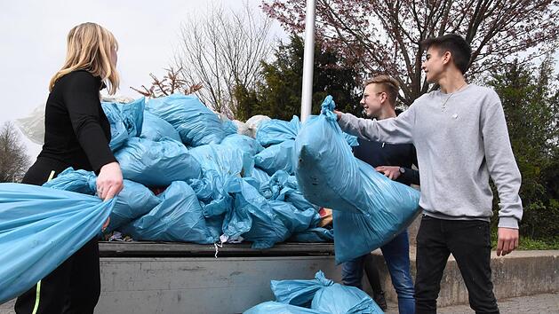 Valerie Eske, Lars Moschnitschka und Moritz Kneuer (von links) werfen die letzten Säcke auf den Anhänger - diesen Müll haben die Schüler der Dr.-Auguste-Kirchner-Realschule Haßfurt am Freitag an einigen Stellen in Haßfurt gefunden.  Fotos: Christoph Wiedemann