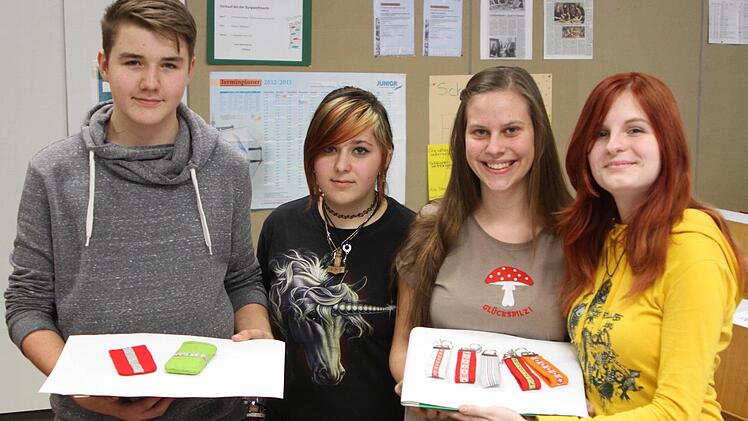 Mit Stolz präsentierten die Firmenvertreter Maximilian Benkert, Julia Zenk, Anna Größ und Lea Alt (von links) ihre Produkte wie Handytaschen und Schlüsselanhänger.