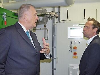 Stadtwerkeleiter Michael Eckardt (links) erklärt Staatsminister Thorsten Glauber, wie das Blockheizkraftwerk funktioniert. Foto: Rainer Lutz