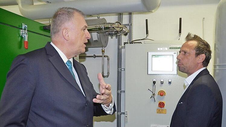 Stadtwerkeleiter Michael Eckardt (links) erklärt Staatsminister Thorsten Glauber, wie das Blockheizkraftwerk funktioniert. Foto: Rainer Lutz