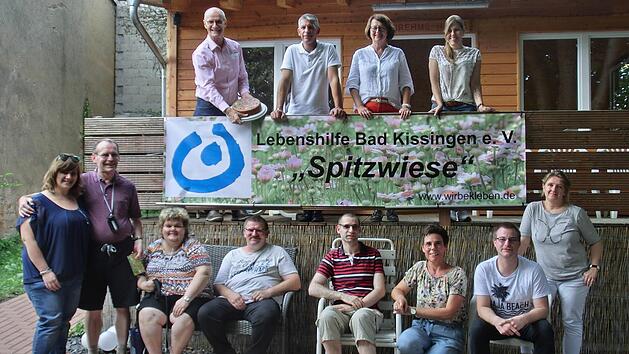 Gemeinsam mit Vorstandskollegen, Wohnheimleitung und einem Teil der Bewohner pr&auml;sentierte Aufsichtsratsvorsitzende Monika Fella ein Band mit dem neuen Namen Haus "Spitzwiese" des Lebenshilfe-Wohnheimes in der Hartmannstra&szlig;e. Auf unserem Foto (von links, obere Reihe) Vorstand Alex Iffert, die Aufsichtsr&auml;te Frank Dittrich, Margarete Heusinger, Helga Markard und die stellvertretende Heimleiterin Steffi Bittner. In der unteren Reihe v.li.: die Heimbewohner Klaus Schwarz, Manuela Zehe, Wolfgang Bo...