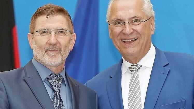 Michael Busch erh&auml;lt von Innenminister Joachim Herrmann die kommunale Verdienstmedaille.  Foto: Sammy Minkoff