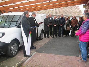 Pfarrer Robert Augustin und Diakon Manfred Müller (links) weihten die neuen Fahrzeuge im Beisein des Tafelpersonals und der Spender.  Foto: Winfried Ehling