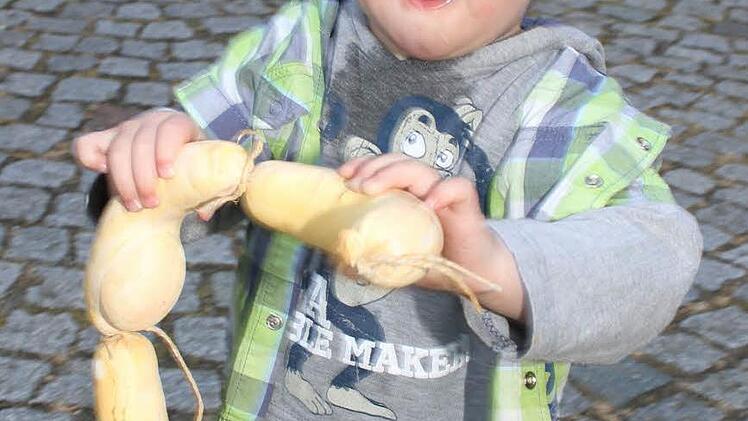 Klein Simon hat schnell gelernt und sich eine Deko-Siedwurst aus Plastik geschnappt - sehr zur Erheiterung der Gäste.
