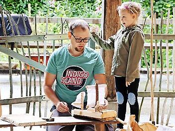 Isabell freut sich, dass ihr Vater Sebastian die Segel an dem kleinen Boot anbringt.