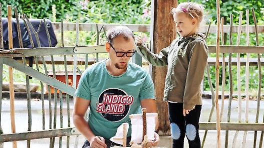 Isabell freut sich, dass ihr Vater Sebastian die Segel an dem kleinen Boot anbringt.