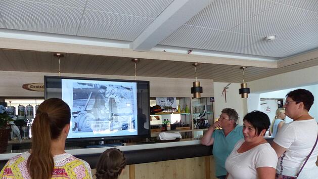 Wirtin Alexandra Schlemmer (r.) erklärt anhand von alten Bildern die Geschichte des  Hauses. Foto: Pauline Lindner