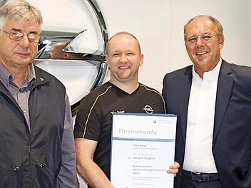 Jürgen (links) und Heinz Dietz (rechts) überreichten die Urkunde der Handwerkskammer an Tino Bauer. Foto: Ralf Kestel