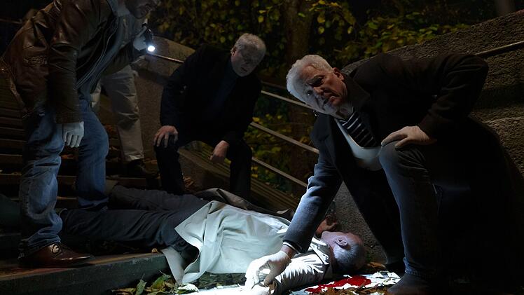 Ivo Batic (Miroslav Nemec, rechts) und Franz Leitmayr (Udo Wachtveitl) inspizieren den Tatort. Ein 70-J&auml;hriger, der eben noch um die Ecke Fasching feierte, ist offenbar unter Gewalteinwirkung ums Leben gekommen.