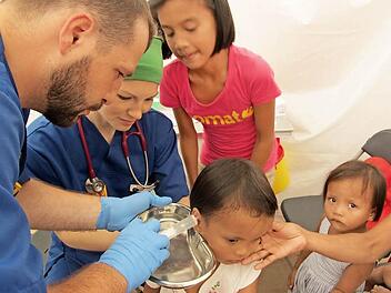 Sebastian Wetzel (rechts) aus Ebenhausen und eine Helferin behandeln ein Kind. Fotos: privat