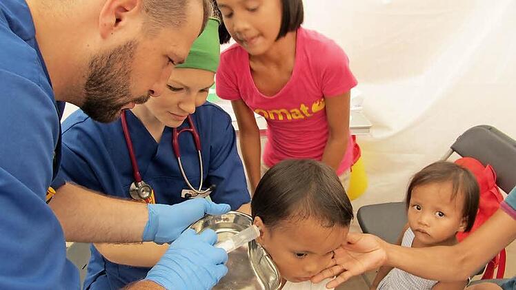 Sebastian Wetzel (rechts) aus Ebenhausen und eine Helferin behandeln ein Kind. Fotos: privat