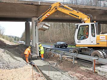 Mitarbeiter der Firma Stolz bauen aktuell die Fertigteile für eine Stützmauer unter der Brücke ein. Fotos: Ralf Ruppert
