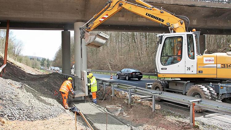 Mitarbeiter der Firma Stolz bauen aktuell die Fertigteile für eine Stützmauer unter der Brücke ein. Fotos: Ralf Ruppert