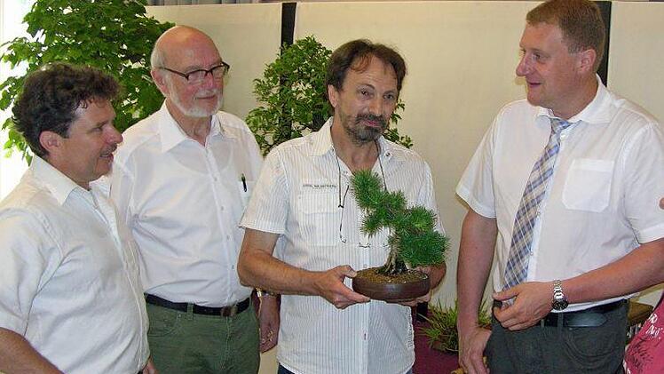 Peter Schardt, Vorsitzender der jubilierenden Bonsaifreunde Altenkunstadt (Bildmitte) erläutert Details zum Bonsaihobby. Mit im Bild von links: Regionalverbandsleiter Guido Braun, Präsident des Bonsaiclub Deutschland Elmar Heil, Bürgermeister Michael Keilich mit Ehefrau Nadine. Foto: Klaus Oelzner