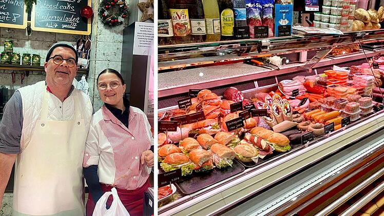 Zwei Personen in Metzgerei vor Fleischtheke. Schilder mit Preisen und Angeboten, darunter Sandwiches und Würste. Weihnachtliche Dekoration im Hintergrund.