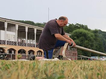 Dieter Dittrich beim Vorbereiten der Drainage des Springplatzes. Im Hintergrund das historische Turniergebäude. Foto: Doris Bauer