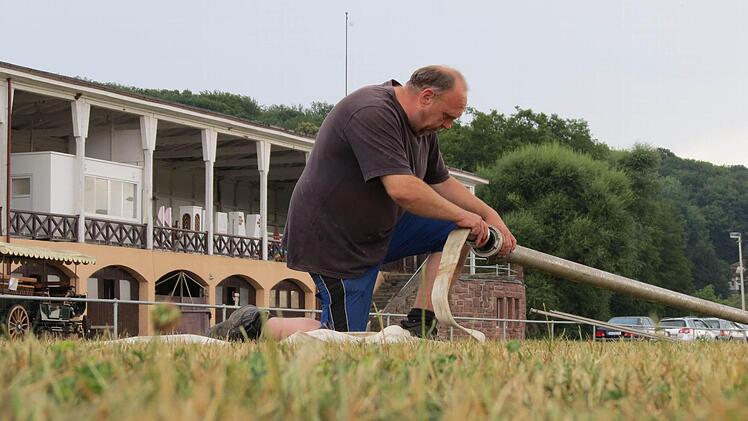 Dieter Dittrich beim Vorbereiten der Drainage des Springplatzes. Im Hintergrund das historische Turniergebäude. Foto: Doris Bauer