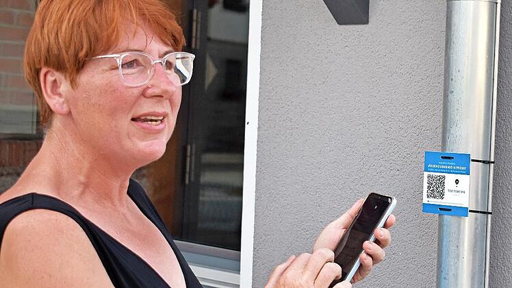 Per QR-Code erfährt man beim Dorfrundgang Wissenswertes über das jüdische Leben in Friesen. Heidi Hansen zeigte den Interessierten, wie man’s richtig macht.