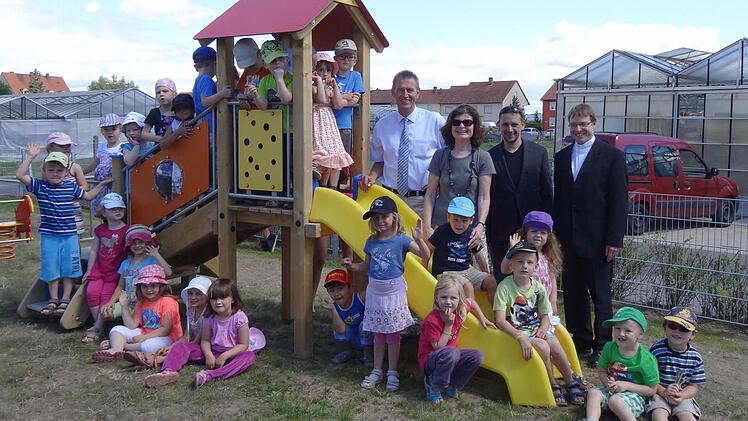 Sie strahlen mit der Sonne um die Wette: Oberbürgermeister Siegfried Müller, Diakon Holger Schleyer-Dubowy, Pfarrer Manfred Bauer und die Kinder des Kindergartens St. Michael aus Etwashausen. Foto: Stühler