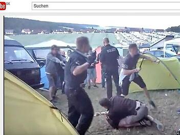 Ein Beamter in Zivil rangelt mit dem Verdächtigen, ein Zivilbeamter hält den Schlagstock in die Höhe. Der Polizist im vorne hat in seinen Händen Stock und Pfefferspray, um sich u wehren. Schlagstock und Spray wurden nicht eingesetzt.  Foto: youtube.com/watch?v=nWNVDJLAKF0