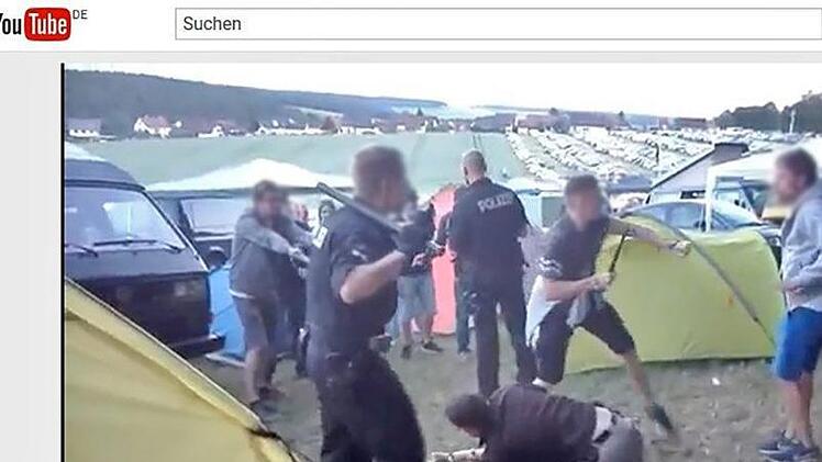 Ein Beamter in Zivil rangelt mit dem Verdächtigen, ein Zivilbeamter hält den Schlagstock in die Höhe. Der Polizist im vorne hat in seinen Händen Stock und Pfefferspray, um sich u wehren. Schlagstock und Spray wurden nicht eingesetzt.  Foto: youtube.com/watch?v=nWNVDJLAKF0