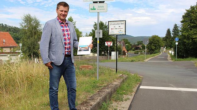 B&uuml;rgermeister Matthias Hauke mit dem St&auml;dtebaulichen Entwicklungskonzept in den H&auml;nden. Am Rh&ouml;nexpress-Radweg soll es zuk&uuml;nftig auch f&uuml;r Radtouristen einen Grund zum Anhalten geben. Foto: Julia Raab
