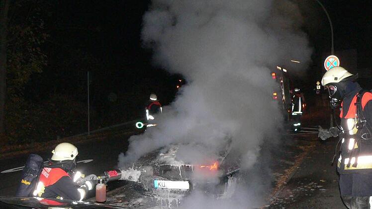 Feuerwehrleute mit Schwerem Atemschutz  setzten  Schaumlöscher zur Brandbekämpfung ein.