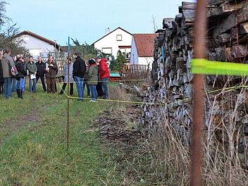 Mitglieder des Bauausschusses und Nachbarn besichtigen die mit gelber Schnur abgesteckten Umriss der Wohnhäuser. Foto: Arkadius Guzy