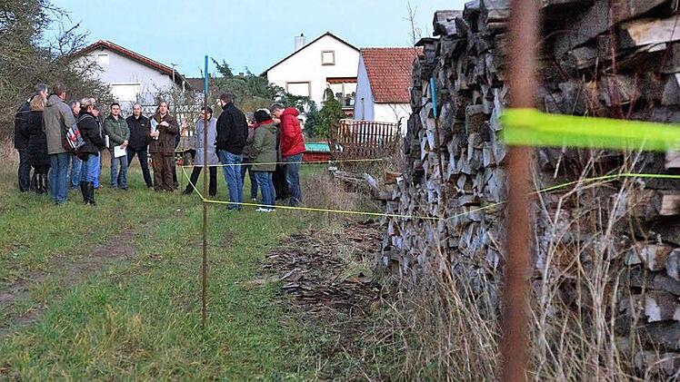 Mitglieder des Bauausschusses und Nachbarn besichtigen die mit gelber Schnur abgesteckten Umriss der Wohnhäuser. Foto: Arkadius Guzy